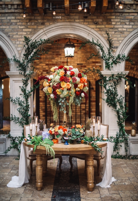 HIgh and low table design with ivy decor in background}