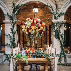 HIgh and low table design with ivy decor in background